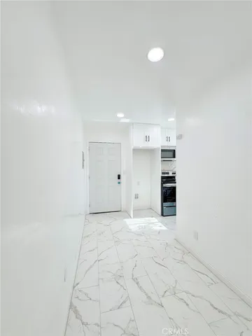 a view of a kitchen with a sink and a refrigerator