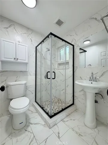 a bathroom with a sink toilet and shower
