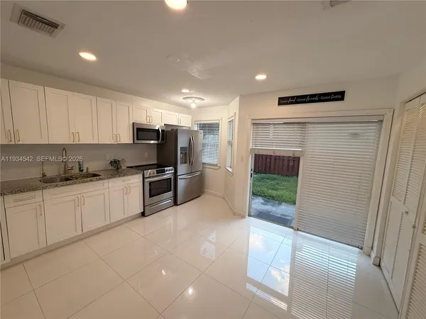 a kitchen with stainless steel appliances granite countertop a refrigerator and a stove top oven