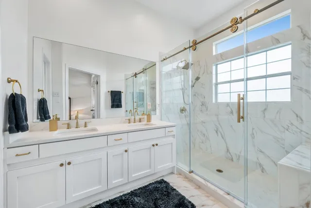 a bathroom with a double vanity sink mirror and shower