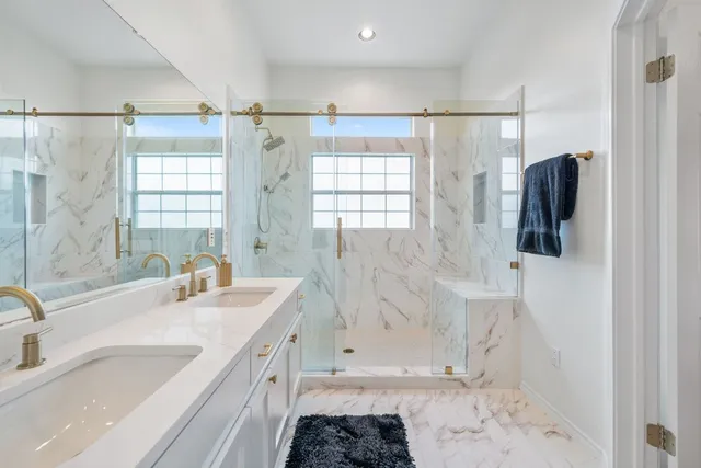 a bathroom with a granite countertop sink a mirror a shower and a bathtub