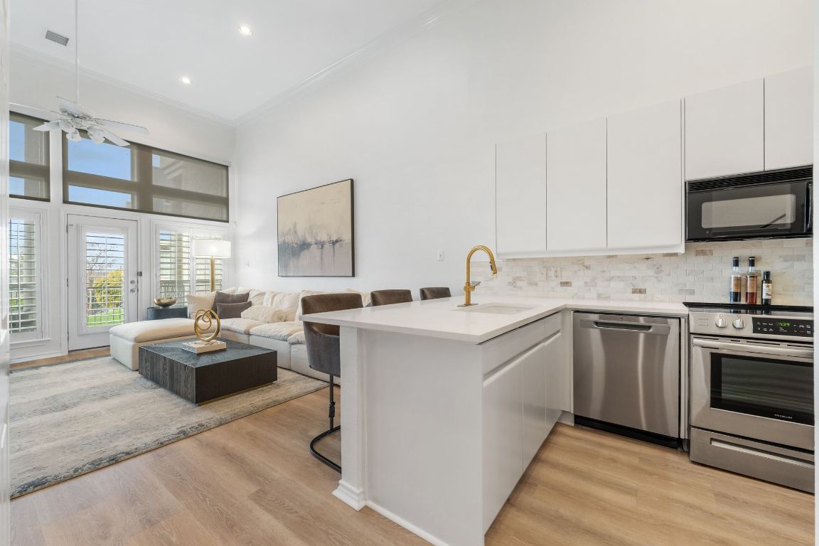 2918 Ranch Road 620, Unit 161 Austin, TX 78734 - Photo 9 of 35 a kitchen with kitchen island granite countertop a sink cabinets and stainless steel appliances