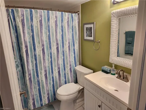 a bathroom with a sink a toilet and shower curtain