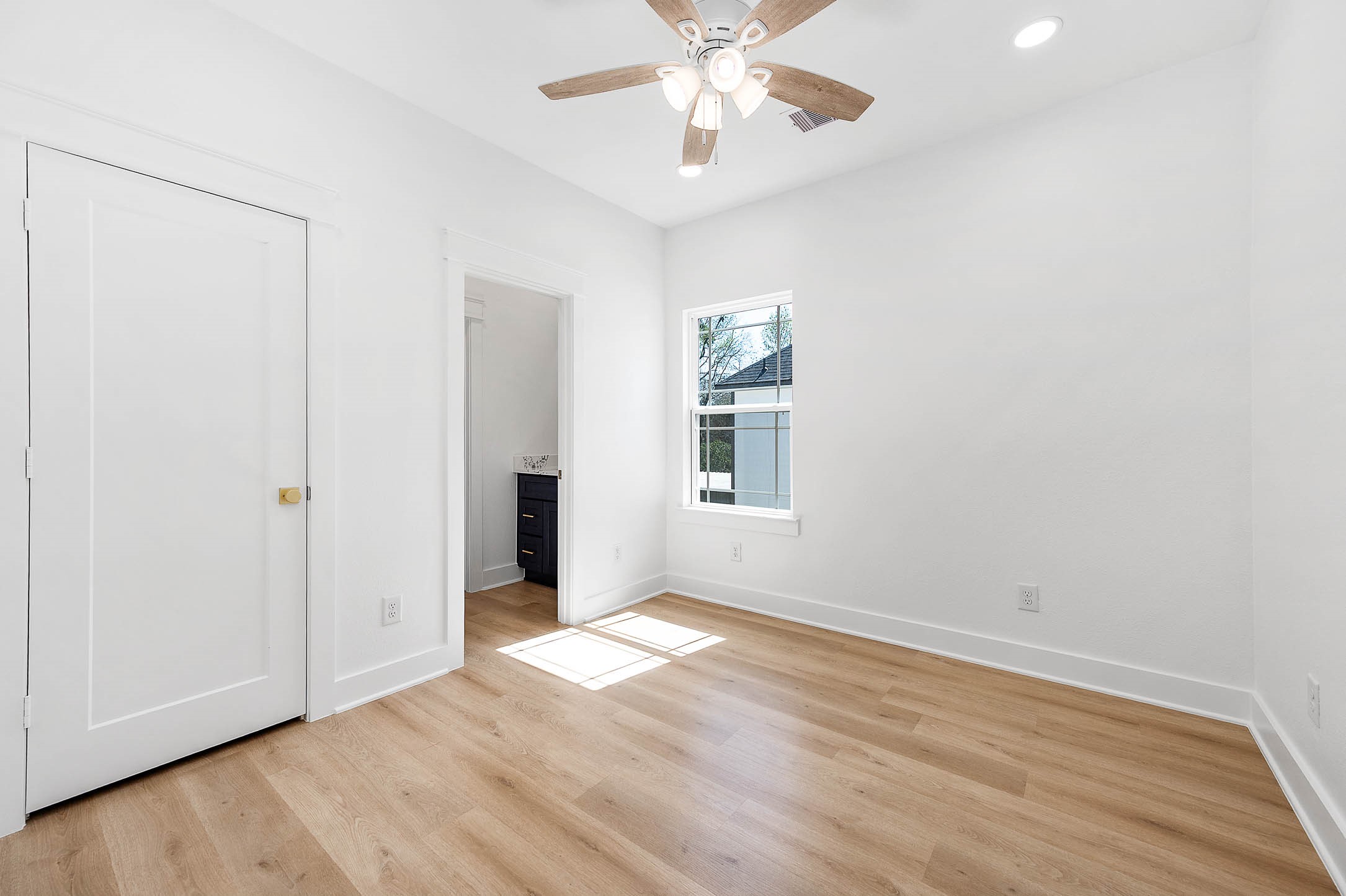 8602 Hoffman Street Houston, TX 77016 - Photo 23 of 30 Bright secondary bedroom featuring warm wood flooring, ceiling fan, and natural light with convenient access to the adjoining bath.