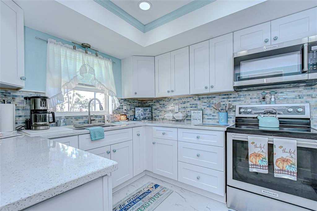 9700 Starkey Road, Unit 111 Seminole, FL 33777 - Photo 12 of 46 a kitchen with stainless steel appliances granite countertop a stove a sink and a microwave