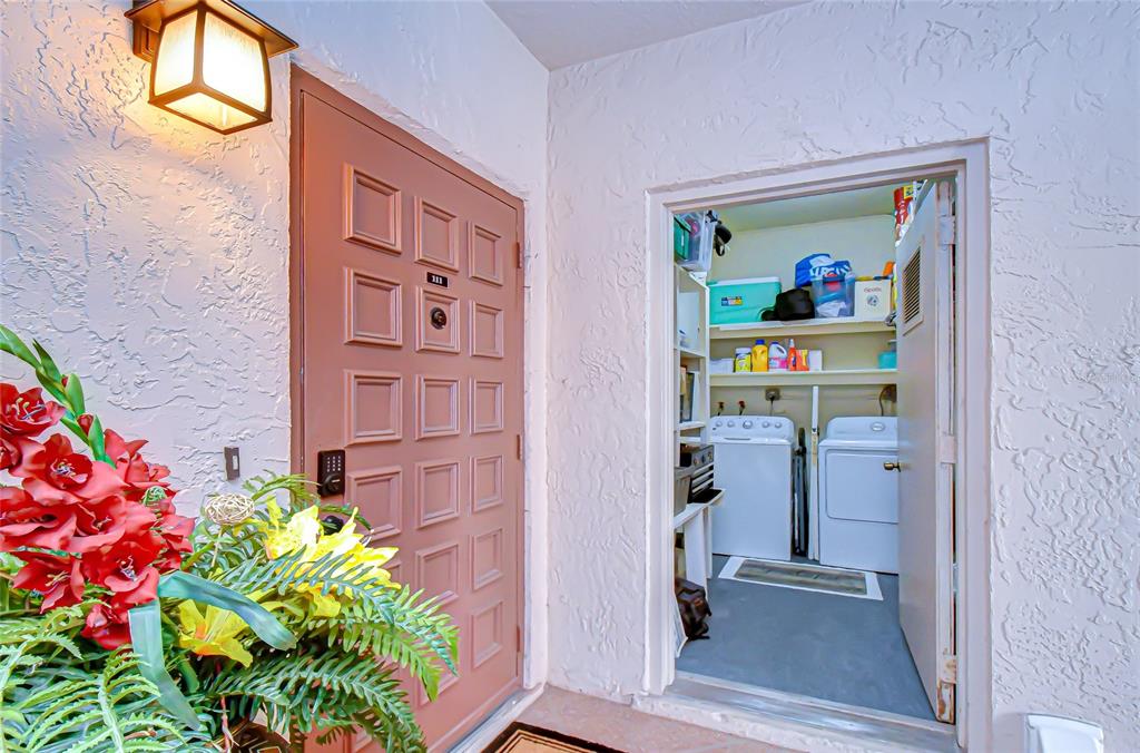 9700 Starkey Road, Unit 111 Seminole, FL 33777 - Photo 6 of 46 a view of a hallway with wooden floor and a potted plant