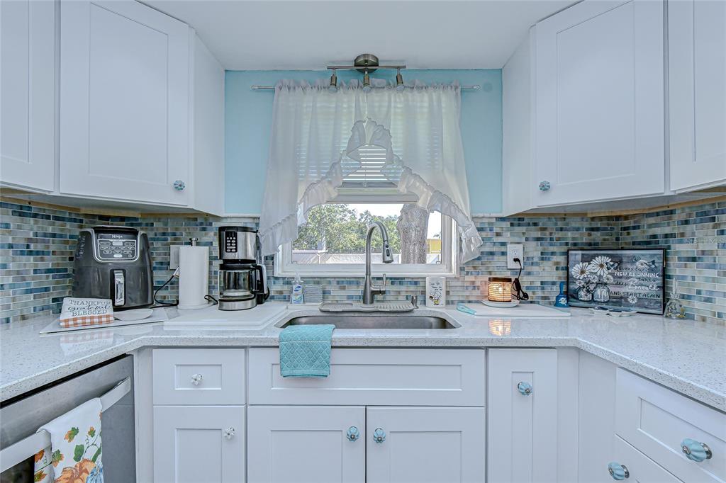 9700 Starkey Road, Unit 111 Seminole, FL 33777 - Photo 9 of 46 a kitchen with a sink a window and cabinets
