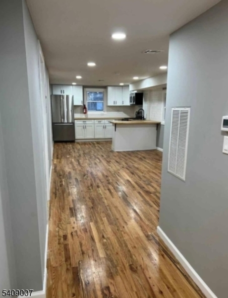149 3rd Street Elizabeth Port, NJ 07206 - Photo 4 of 6 a view of kitchen with kitchen island refrigerator sink and wooden floor