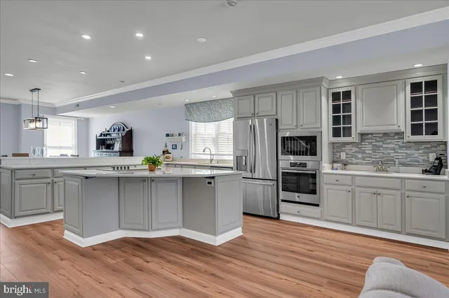a large kitchen with cabinets wooden floor and stainless steel appliances