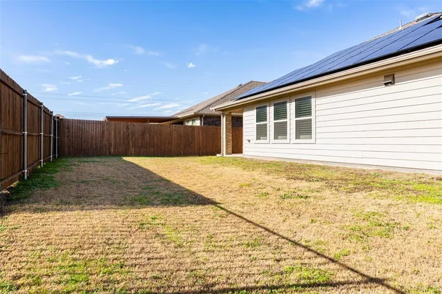a view of house with backyard and wooden fence
