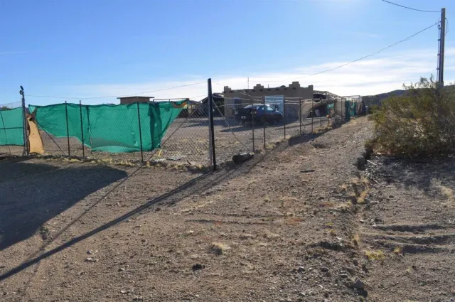 a view of a dry yard with wooden fence