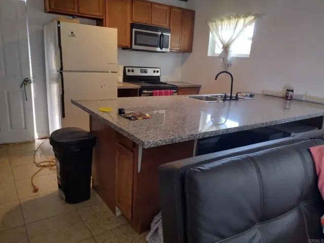 a kitchen with a sink a refrigerator and cabinets