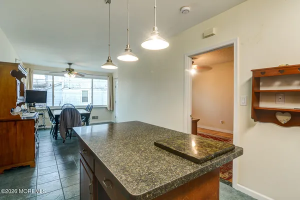 a kitchen with stainless steel appliances granite countertop a sink counter space and living room view
