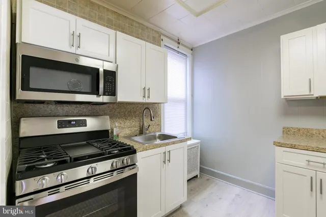 a kitchen with granite countertop cabinets stainless steel appliances and a sink
