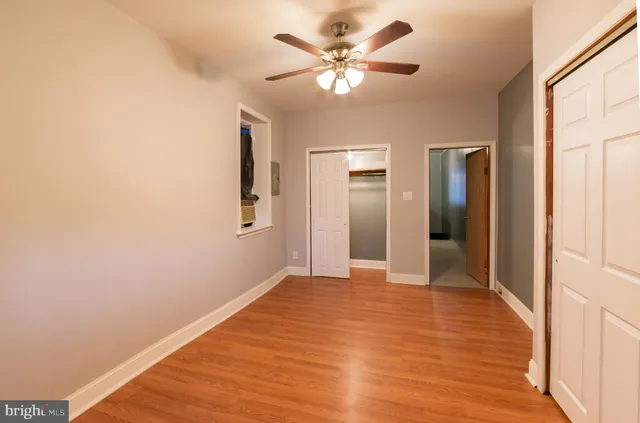 a view of a big room with wooden floor and a ceiling fan
