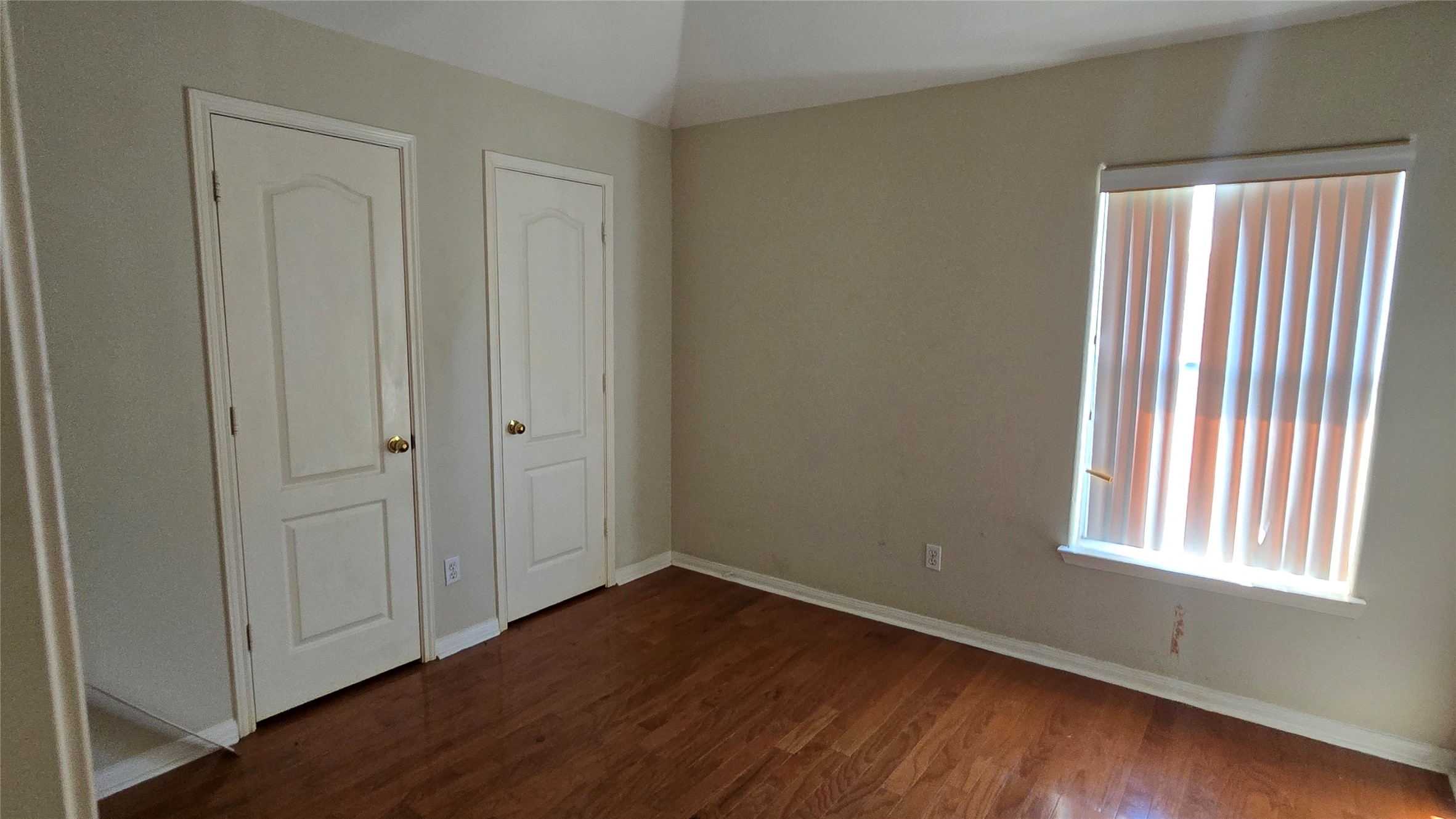 131 Annes Way Stafford, TX 77477 - Photo 17 of 25 an empty room with wooden floor and windows with curtains