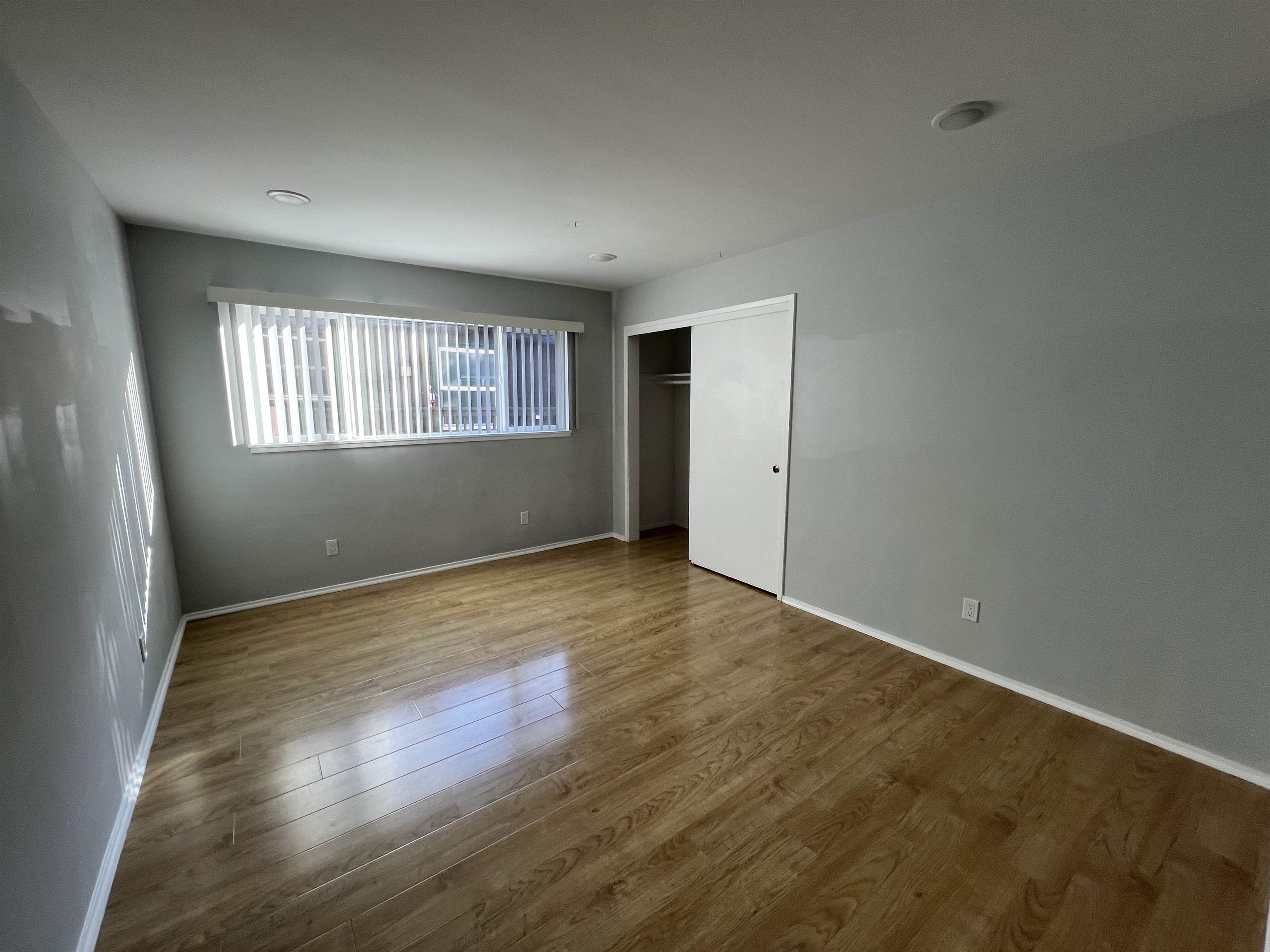 2636 Warring Street, Unit 204 Berkeley, CA 94704 - Photo 2 of 10 an empty room with wooden floor and windows