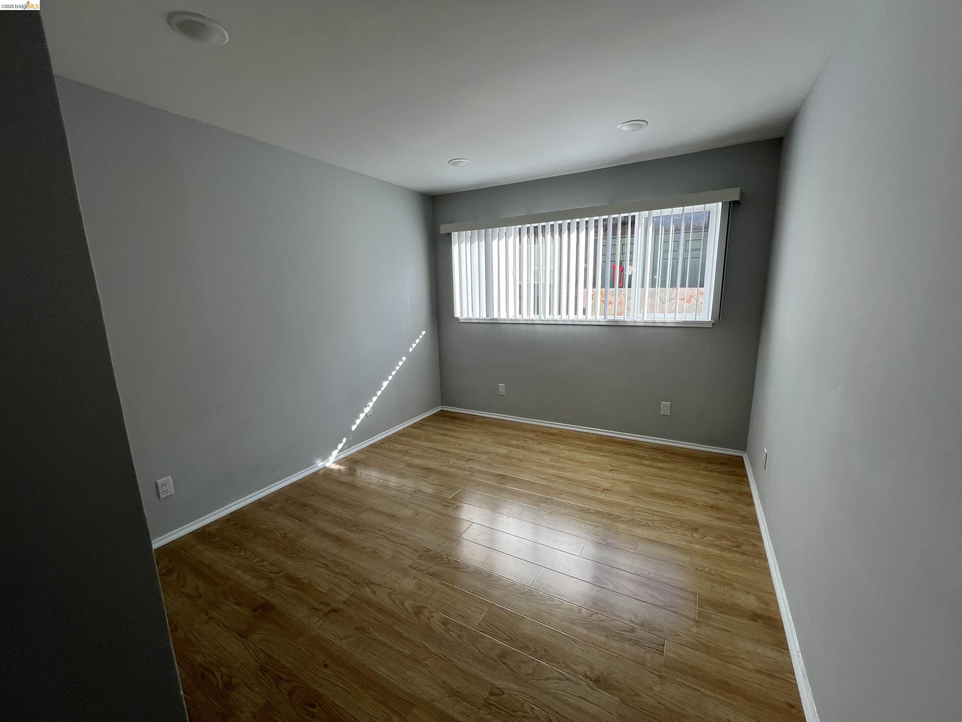 2636 Warring Street, Unit 204 Berkeley, CA 94704 - Photo 4 of 10 an empty room with wooden floor and windows