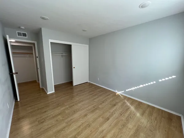 a view of empty room with wooden floor