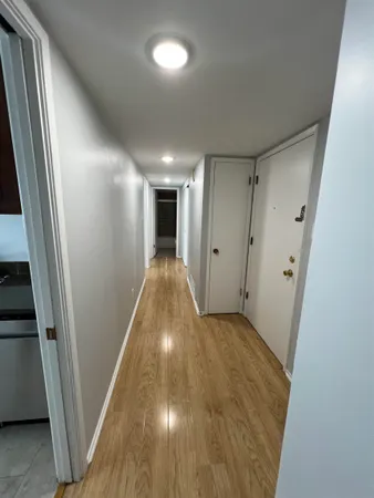 a view of a hallway with wooden floor