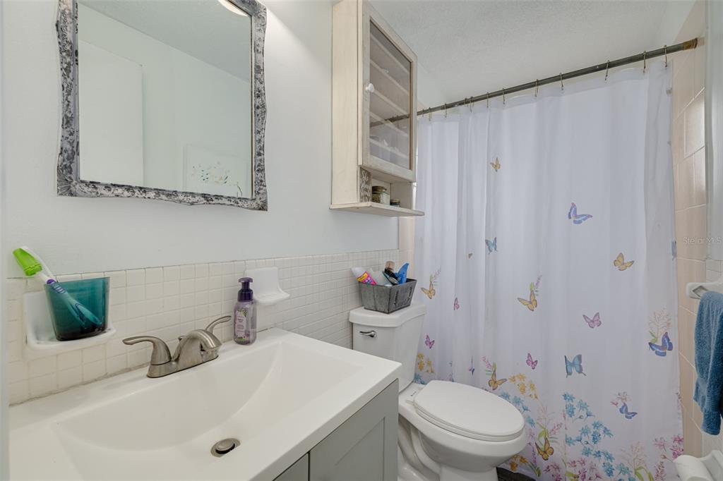 3322 Fairmount Drive Holiday, FL 34691 - Photo 17 of 29 a bathroom with a sink a toilet and shower curtain