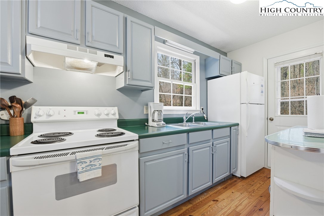 476 Moon Ridge Road Crumpler, NC 28617 - Photo 7 of 35 a kitchen with sink a stove and white cabinets