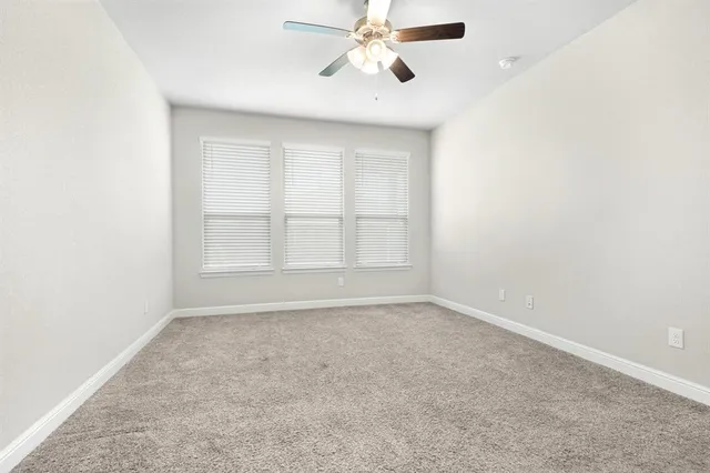 an empty room with a chandelier fan