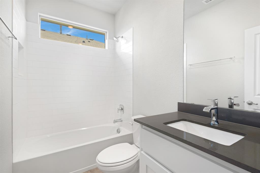 820 Wilmott Terrace Justin, TX 76247 - Photo 14 of 22 a bathroom with a granite countertop sink a toilet and bathtub