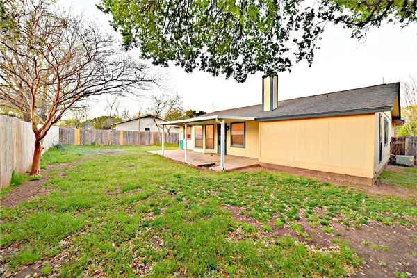 a view of a house with backyard and a tree