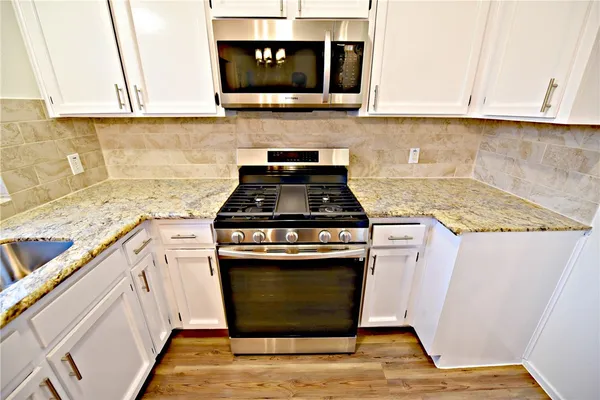 a kitchen with granite countertop a stove and a sink