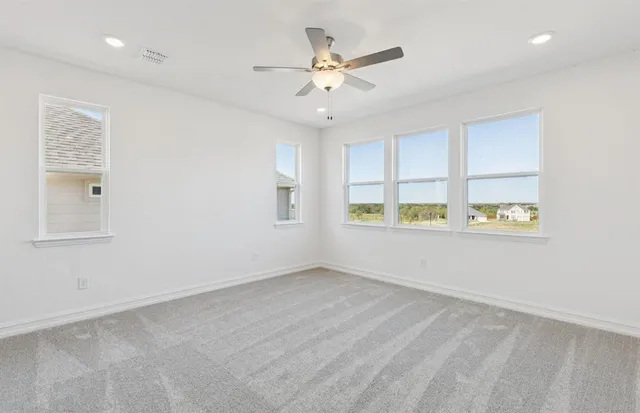 a view of an empty room with a ceiling fan