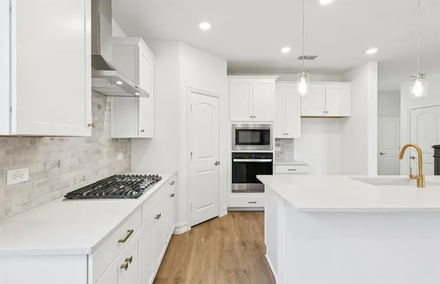 a kitchen with stainless steel appliances granite countertop a refrigerator and a sink