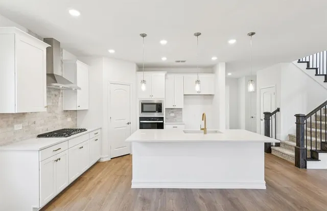 a kitchen with stainless steel appliances a refrigerator sink and stove
