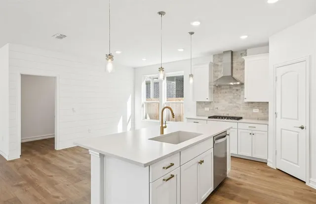 a kitchen with stainless steel appliances a stove a sink and a refrigerator