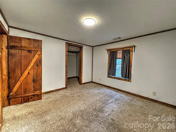 an empty room with a fireplace and cabinet