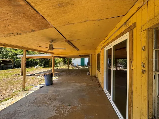 a view of a porch with a table and chairs