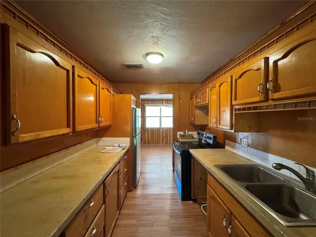 a kitchen with stainless steel appliances a sink stove and cabinets