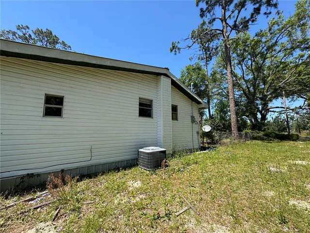 a backyard of a house with fountain table and chairs