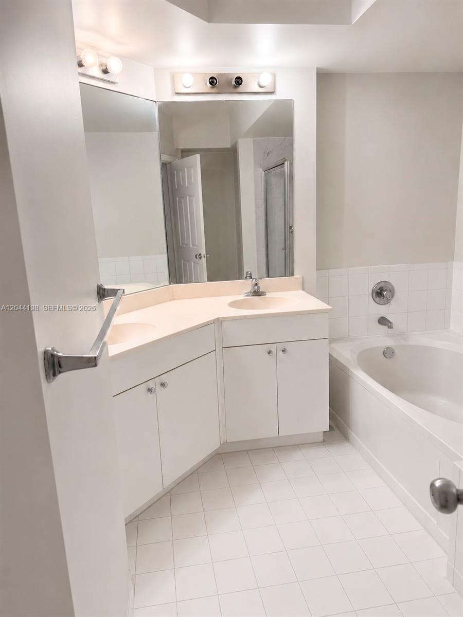 17145 North Bay Road, Unit 4307 Sunny Isles Beach, FL 33160 - Photo 6 of 35 a spacious bathroom with a double vanity sink mirror and bathtub