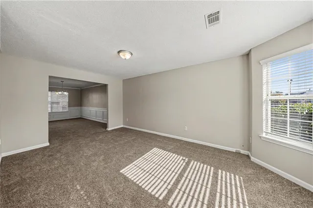 a view of an empty room with stairs and a window