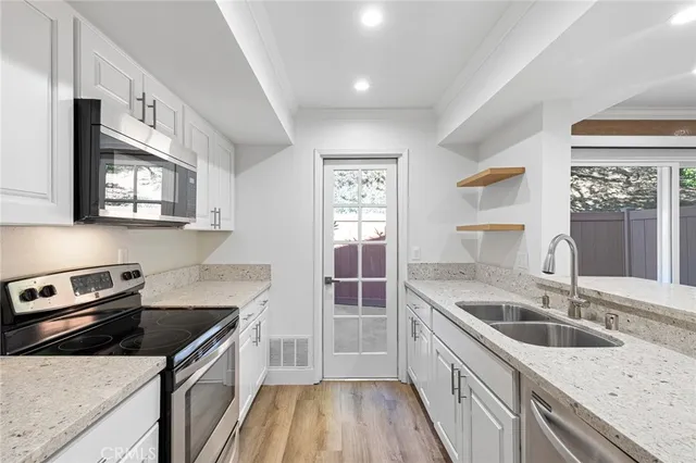 a kitchen with a sink stove top oven and refrigerator