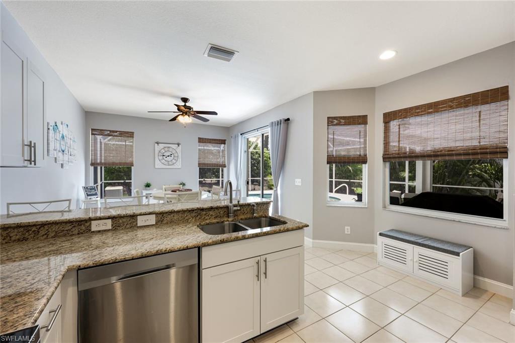 697 Crossfield Circle Naples, FL 34104 - Photo 7 of 18 Kitchen featuring dishwasher, a ceiling fan, light tile patterned floors, stone counters, and recessed lighting