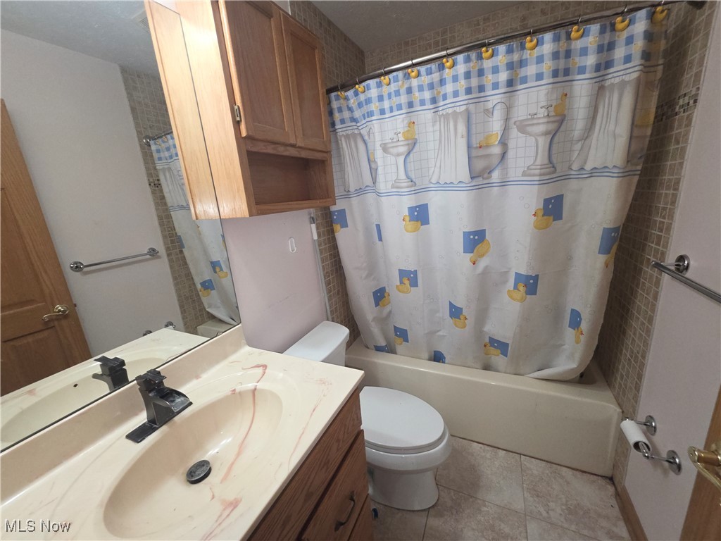 2291 Armstrong Road Wooster, OH 44691 - Photo 6 of 23 Bathroom with vanity, shower / bath combo with shower curtain, and light tile patterned floors