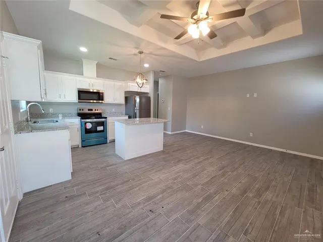 a kitchen with kitchen island a stove a sink and a refrigerator