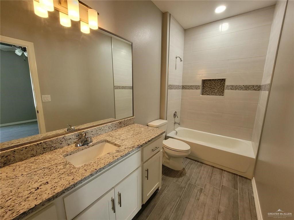 1913 Davenport Street, Unit 2 Weslaco, TX 78596 - Photo 7 of 13 a bathroom with a granite countertop sink toilet and shower