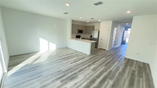 a view of a kitchen with wooden floor and a window