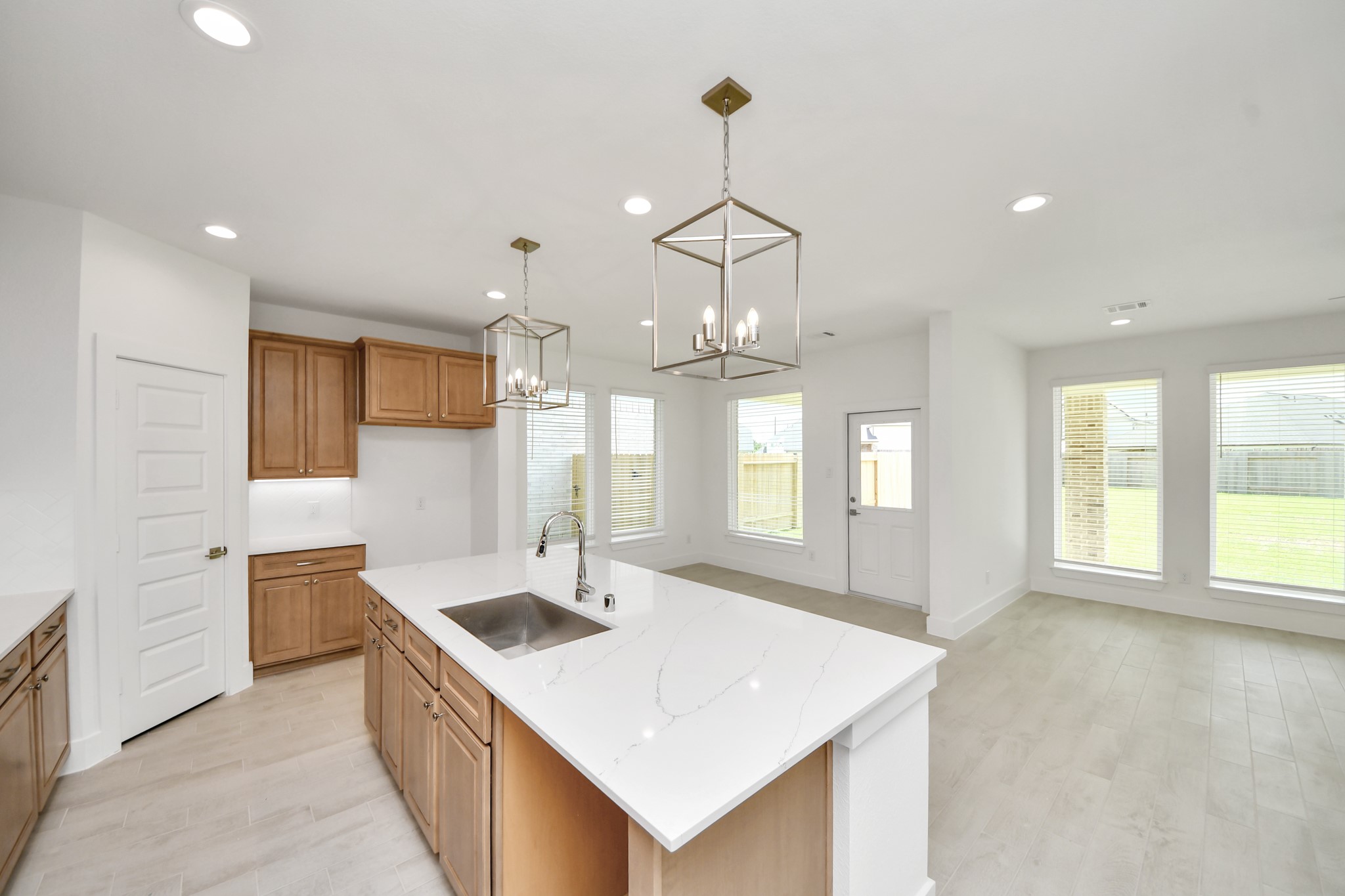 3102 Native Spg Drive Spring, TX 77373 - Photo 12 of 47 This kitchen is truly a chef's dream! This haven Boasts high ceilings, recessed & pendant lighting, stained wood cabinets, granite countertops, stainless steel appliances, a modern tile backsplash. All of this overlooks your expansive family room, creating a perfect space for culinary delights and family gatherings.