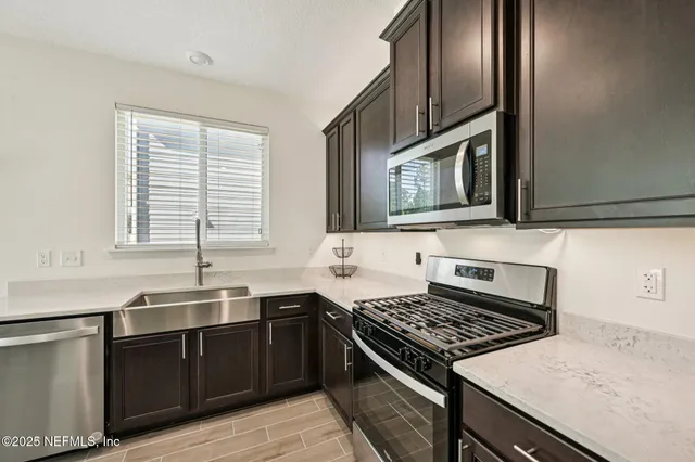a kitchen with stainless steel appliances granite countertop a sink stove and cabinets