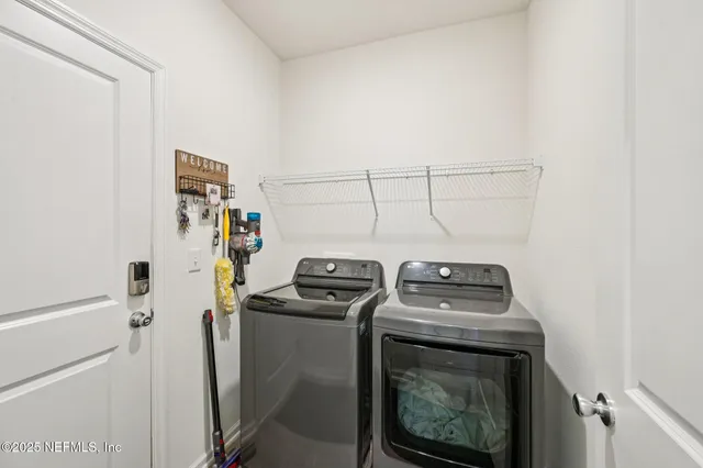 a utility room with dryer washer and empty racks
