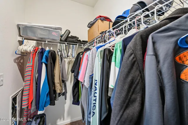 a view of walk in closet with clothes and shoes
